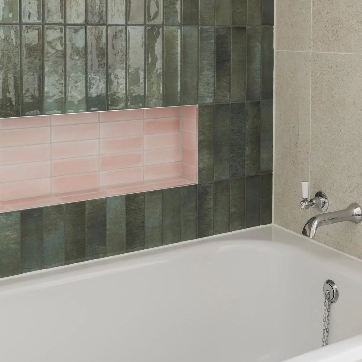A sleek white bathtub with a chrome faucet against south cliff rose brick tile wall
