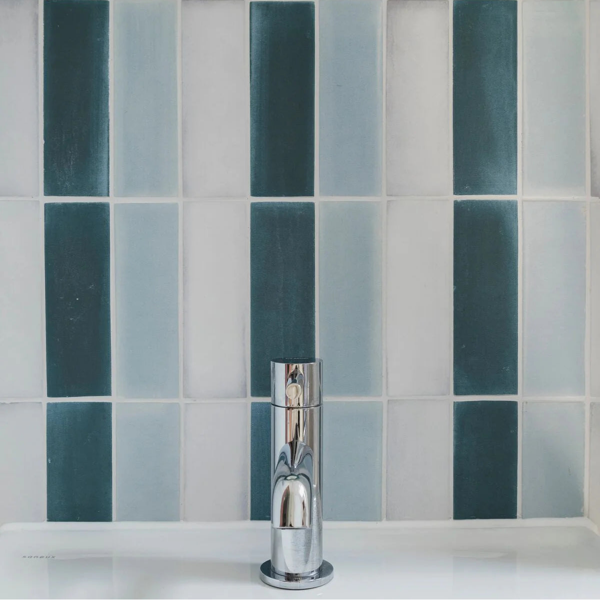 Chrome finished single-handle bathroom faucet with sleek modern design featured in south cliff teal brick tile setting