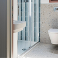 White ceramic wall-mounted sink with sleek modern design paired with teal brick tile background