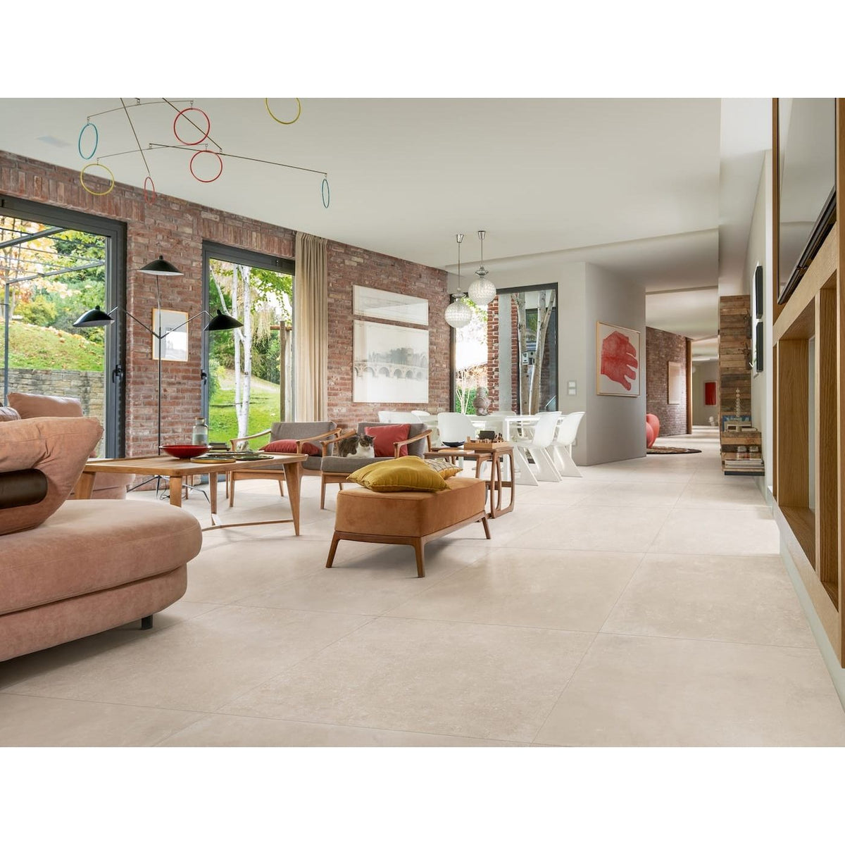 Modern living room with brick wall, large windows, and stylish furniture.