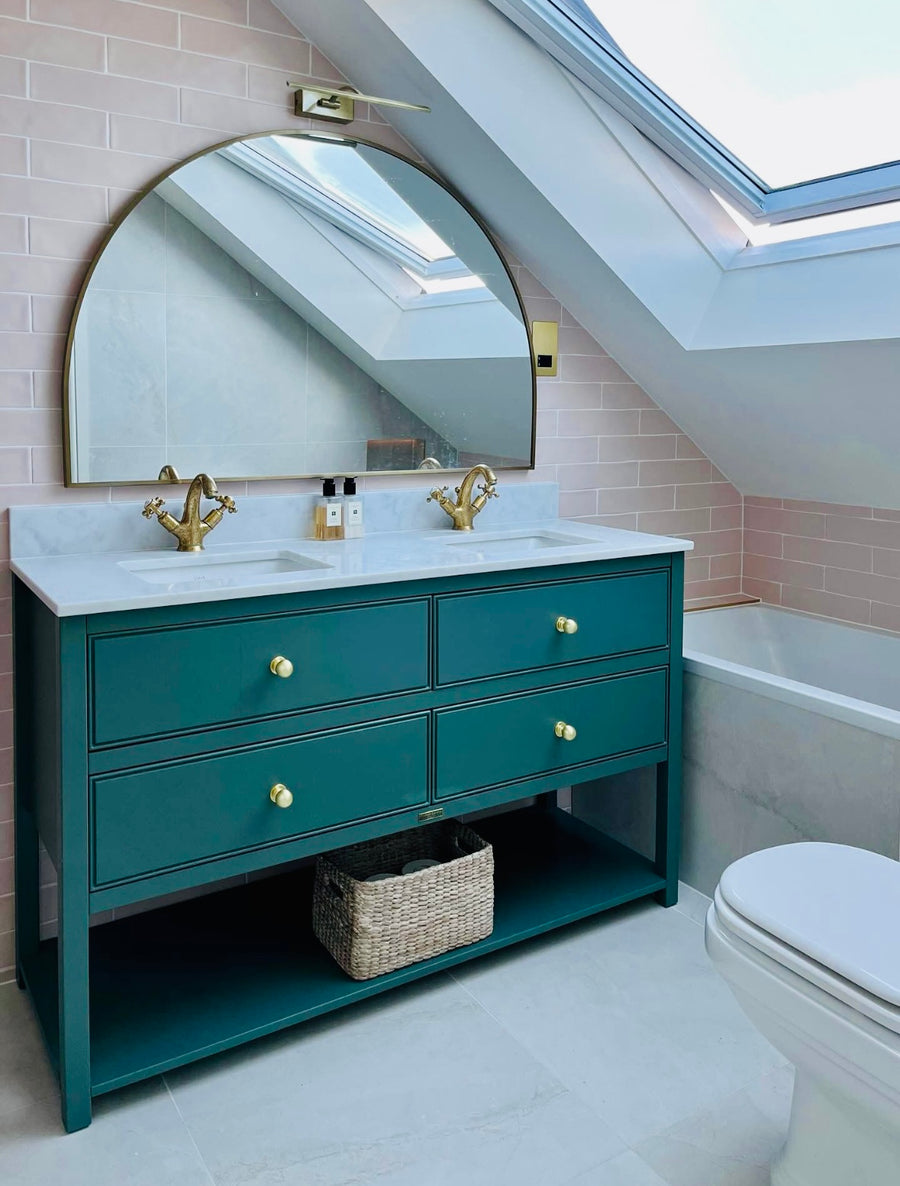 Fondant Ceramic Rose tiles behind a green vanity with brass taps and an arched mirror in Philippa J Rogers’ London loft bathroom