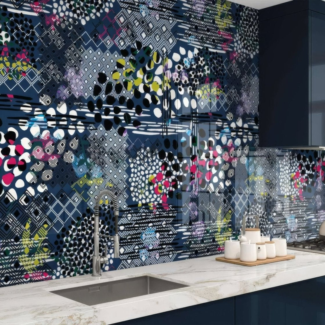 The kitchen backsplash features an abstract pattern navy blue wall panel with bold black white pink and green geometric shapes