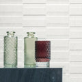 Three glass vases in clear green, pale green, and deep burgundy with textured faceted surfaces for decor use