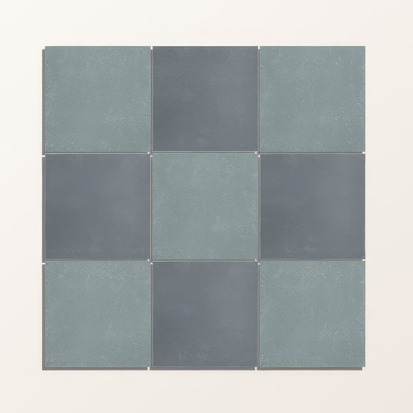 Nine square adventuras blue field porcelain tiles in muted teal and dark gray with a textured finish arranged in a grid