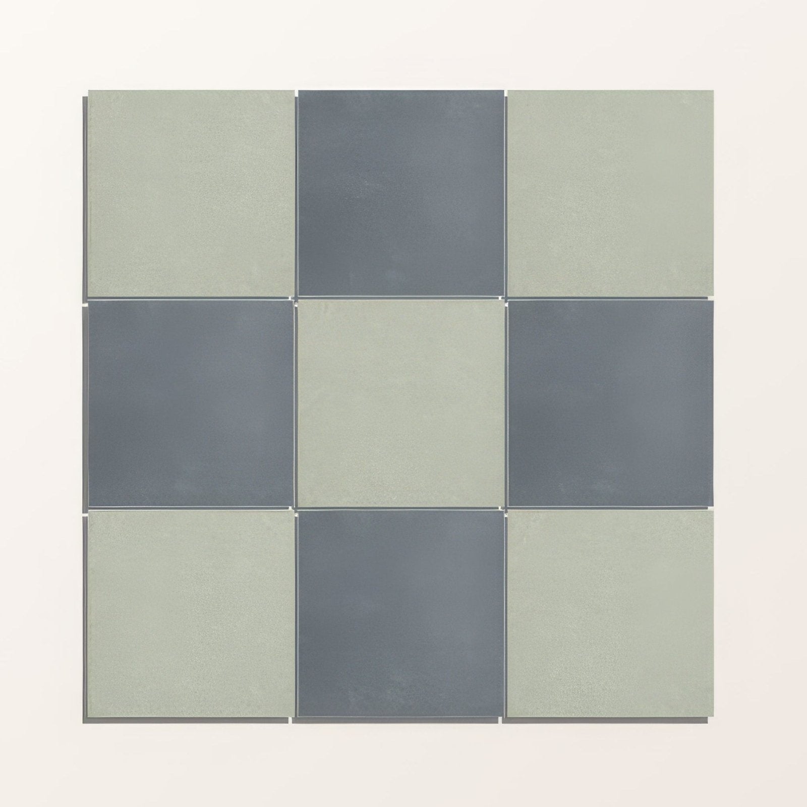 Nine square porcelain tiles from adventuras navy field in matte sage green and muted gray arranged in a 3x3 grid