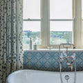 White porcelain bathtub with chrome faucet and handles from adventuras porto blue porcelain collection