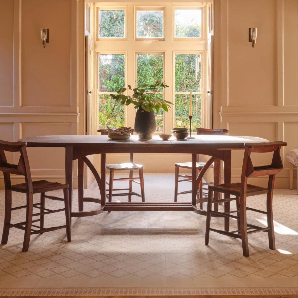 Dark wood dining table with curved legs and smooth polished surface in adventuras porto terracotta porcelain style