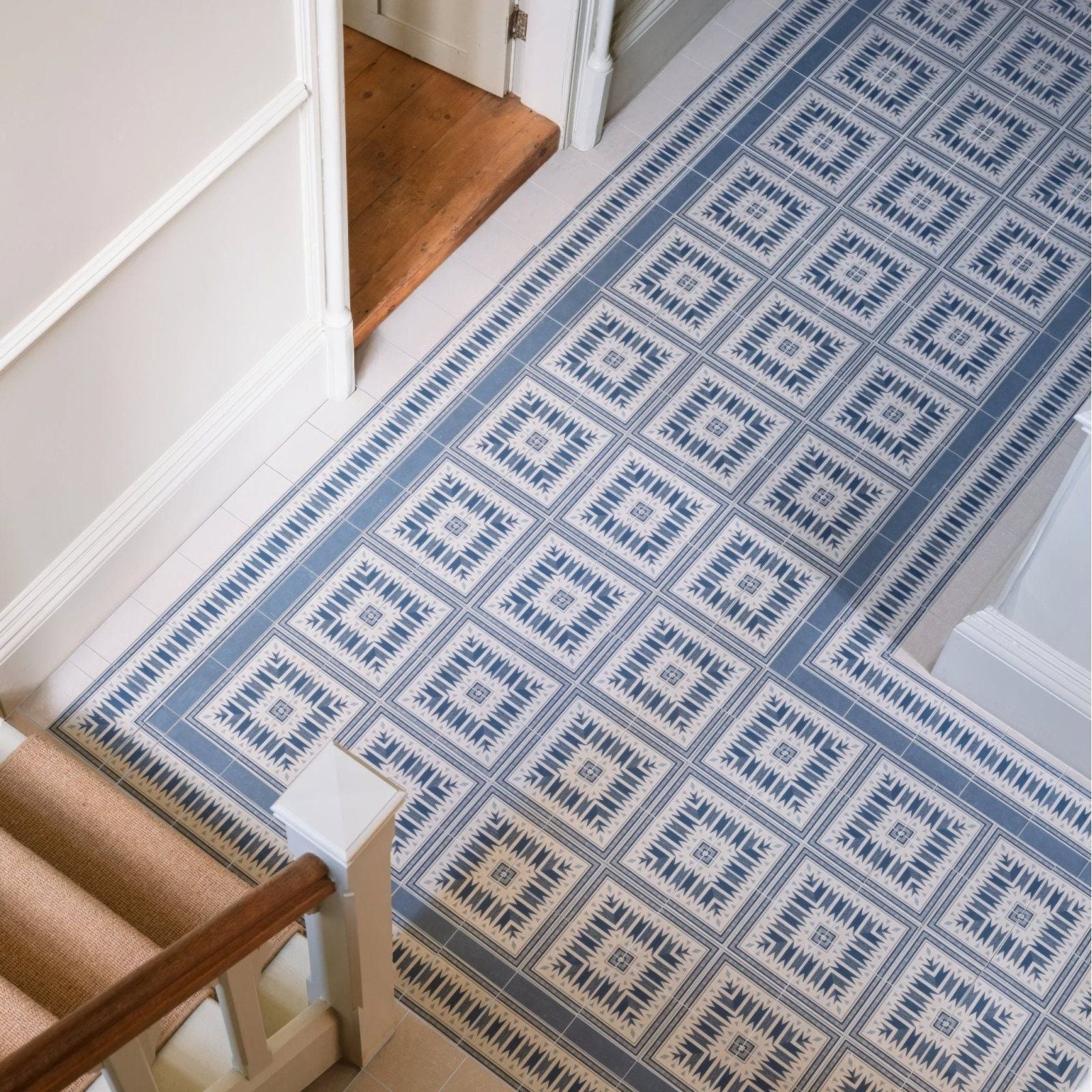 Blue and white geometric patterned floor tile with repeating diamond design made of porcelain called adventuras ziggy corner blue