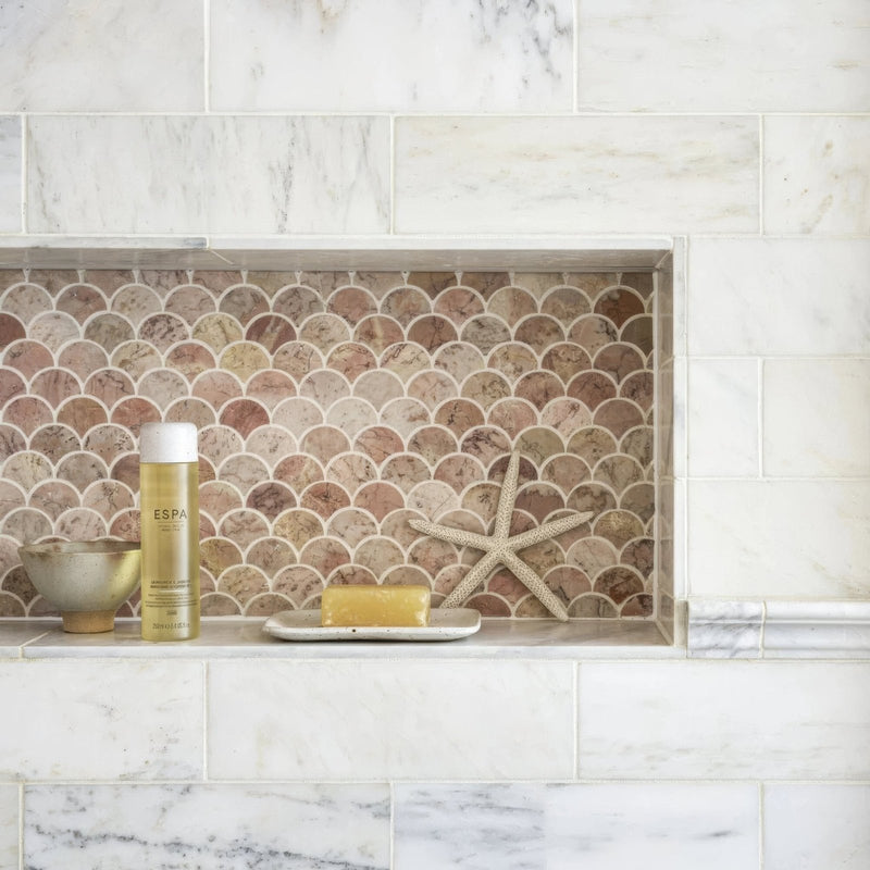 Aegean Pink Scallop Marble Mosaic pink marble scallop mosaic on a marble shelf styled with a spa bottle