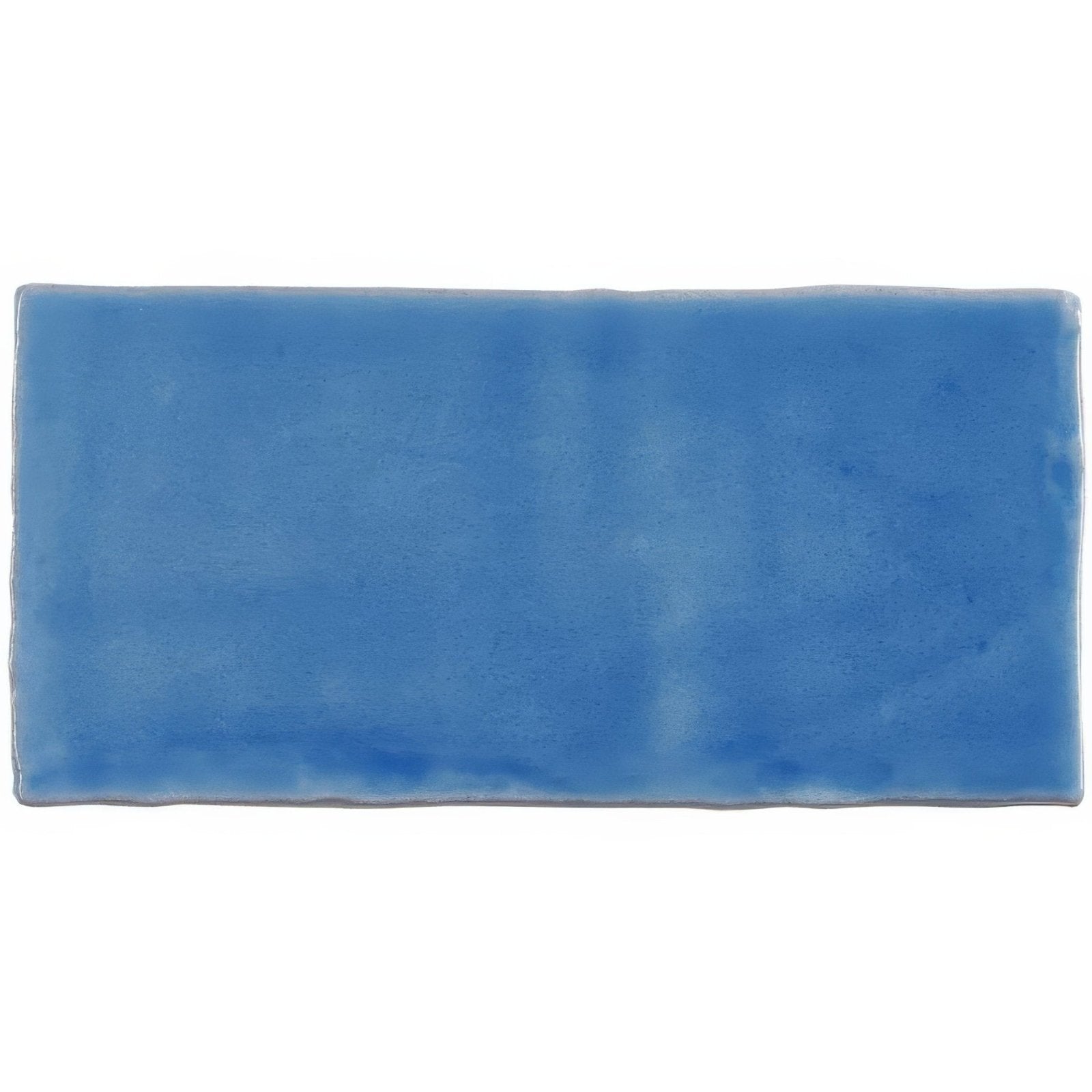 A rectangular blue ceramic agapanthus half tile wall tile with a smooth glazed surface and subtle shade variations