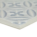 A light gray ceramic Alhambra blue decor glazed tile with a raised intricate geometric pattern