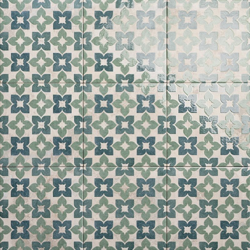 Vintage-style alma green ceramic tiles with repeating quatrefoil pattern in muted green and blue on off-white background