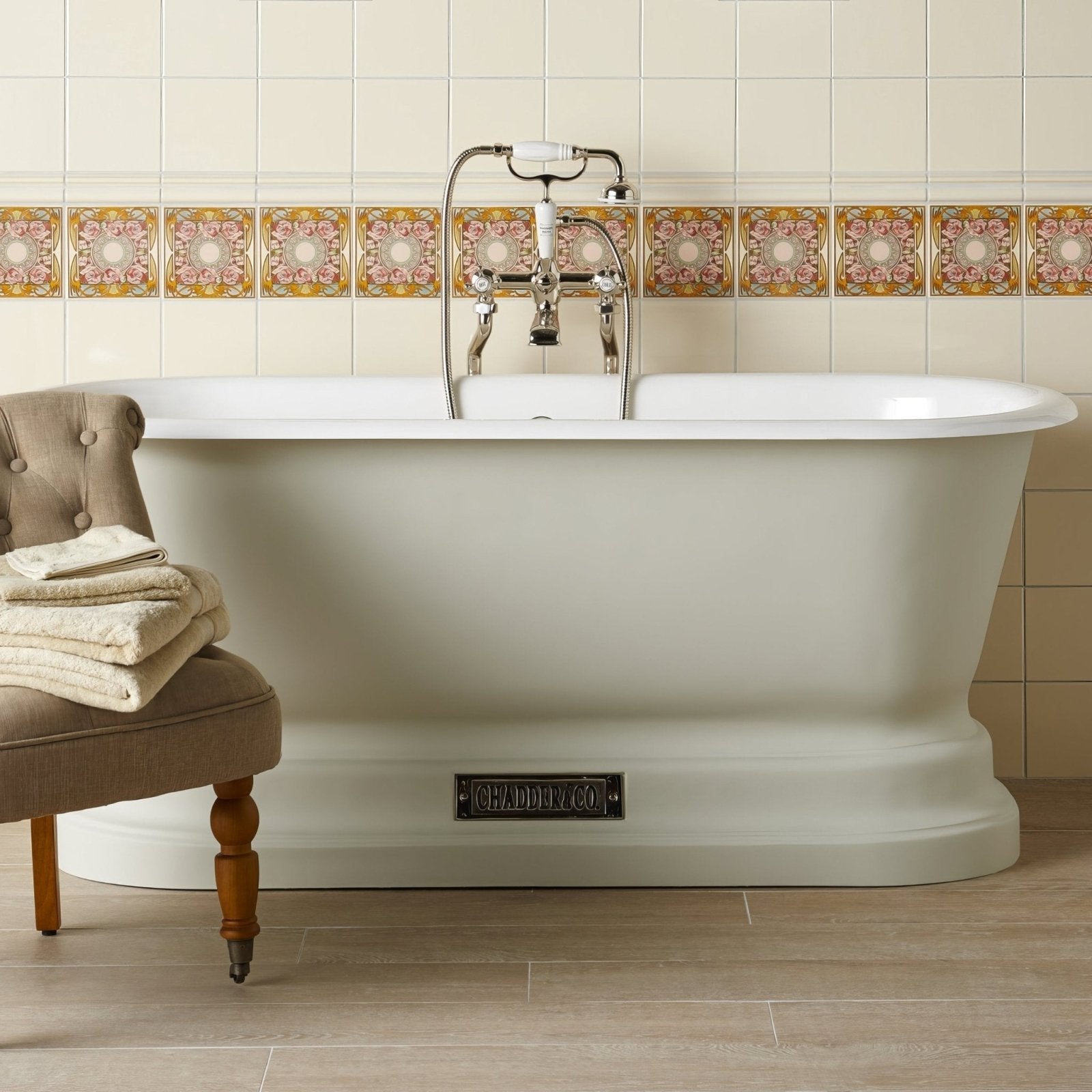 White freestanding bathtub with classic design and chrome faucet featuring chadly co brand plaque on county white tile