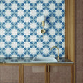 The altea blue taco features a sleek white ceramic rectangular sink with a polished brass faucet on a dark marble countertop