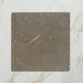 A square matte-finished gray amaya limestone tumbled cabochon tile with subtle white veining and rough texture