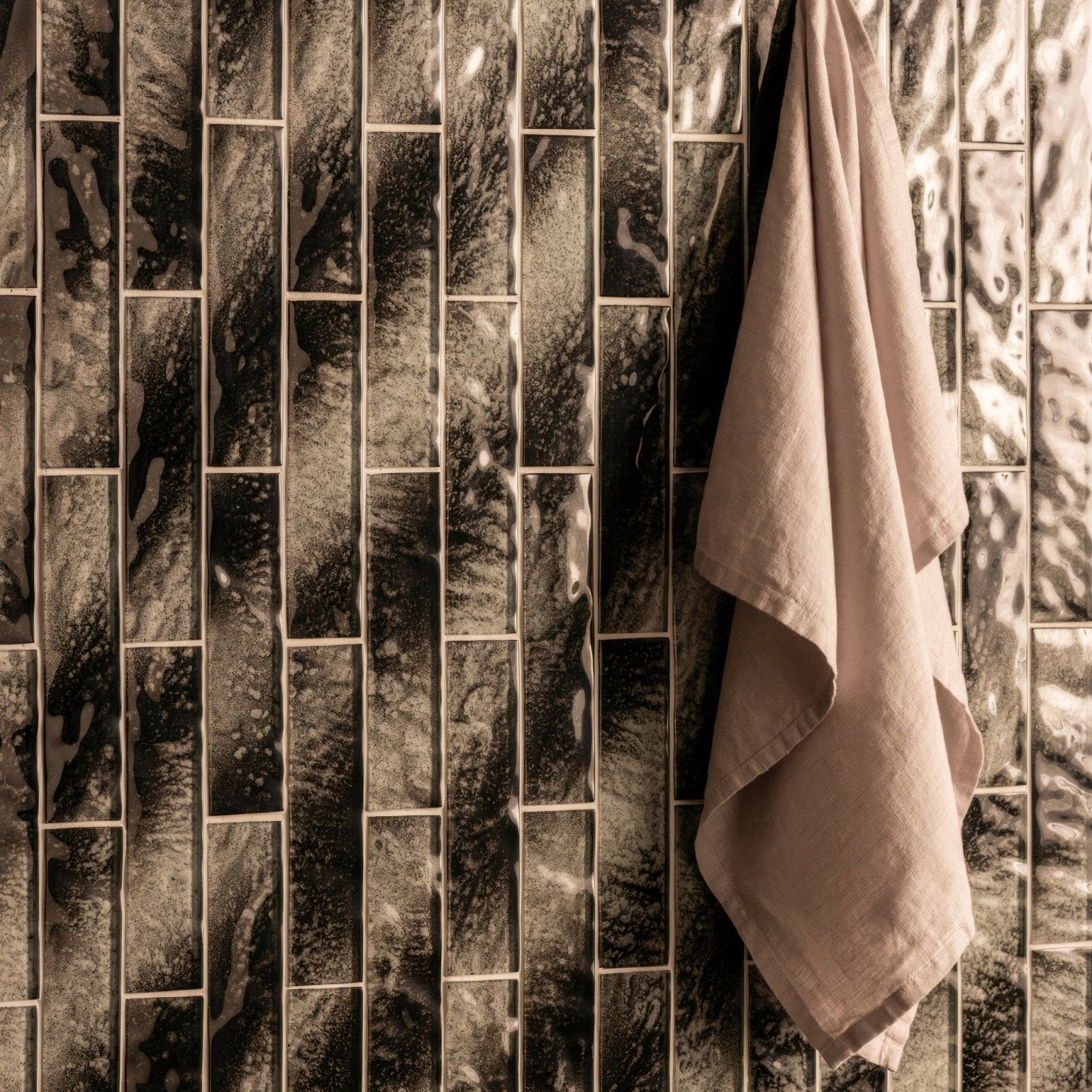 Ammon Brickbond Mosaic dark textured glass brickbond mosaic with a dusty rose towel hanging against it
