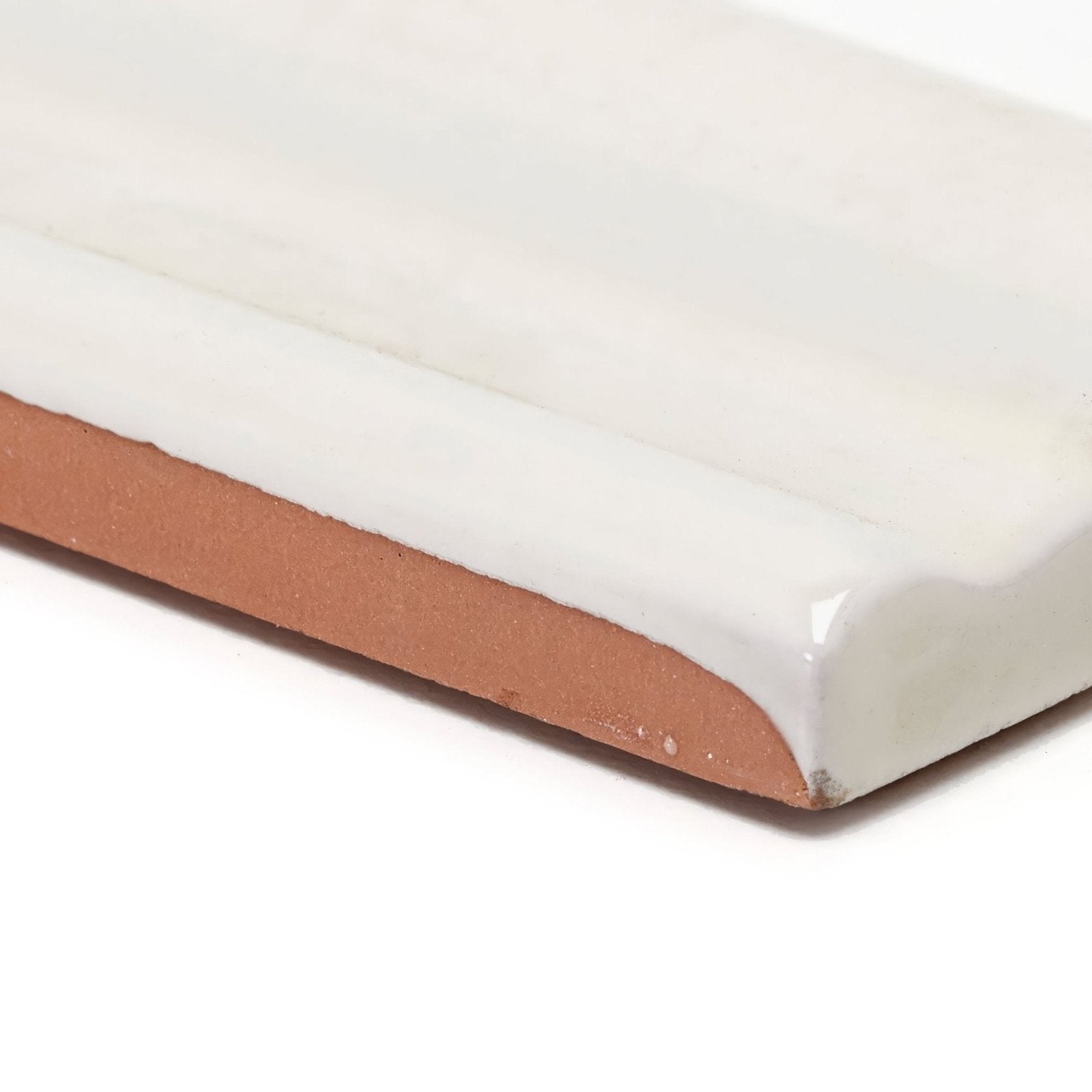 White ceramic tile with a glossy cream finish and terracotta-colored underside back side of andalucia cream glazed dado