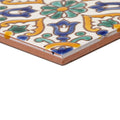 A square ceramic tile with intricate blue green and yellow floral and vine patterns on a white background called andalucia medina patterned tile