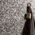 Silver hexagonal aluminium mosaic tile wall with a dark gray textured towel hanging on a black hook