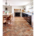 Antique burgundy terracotta reclaimed tile floor with rustic earthy pattern in warm reddish brown and beige tones