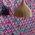 Aqua Scale Clear Mosaic iridescent mermaid-scale glass mosaic wall panel with a beige ribbed pendant lamp