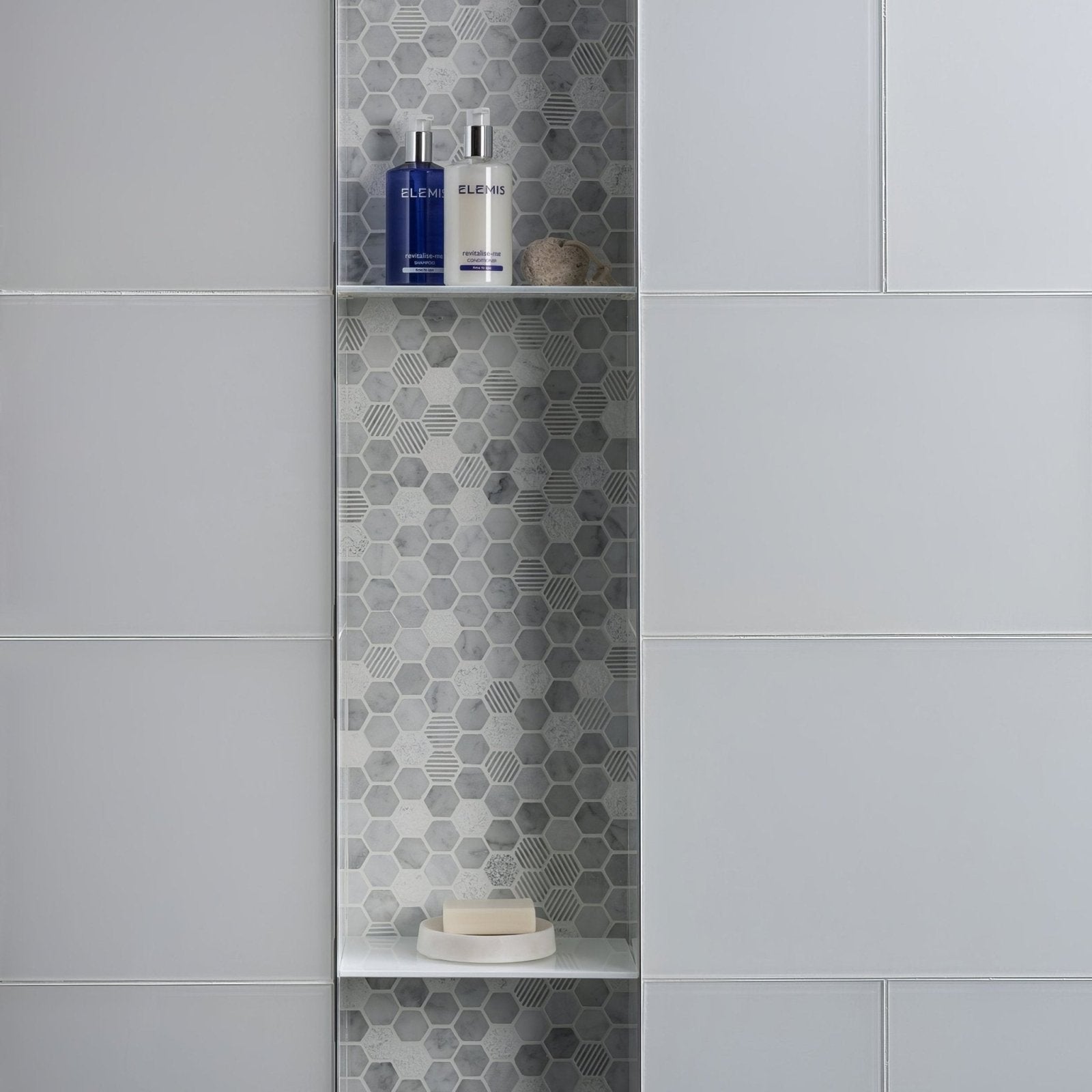 Arctic Clear Glass 600 x 300mm clear glass tiles with a bathroom shelf holding bottles and soap
