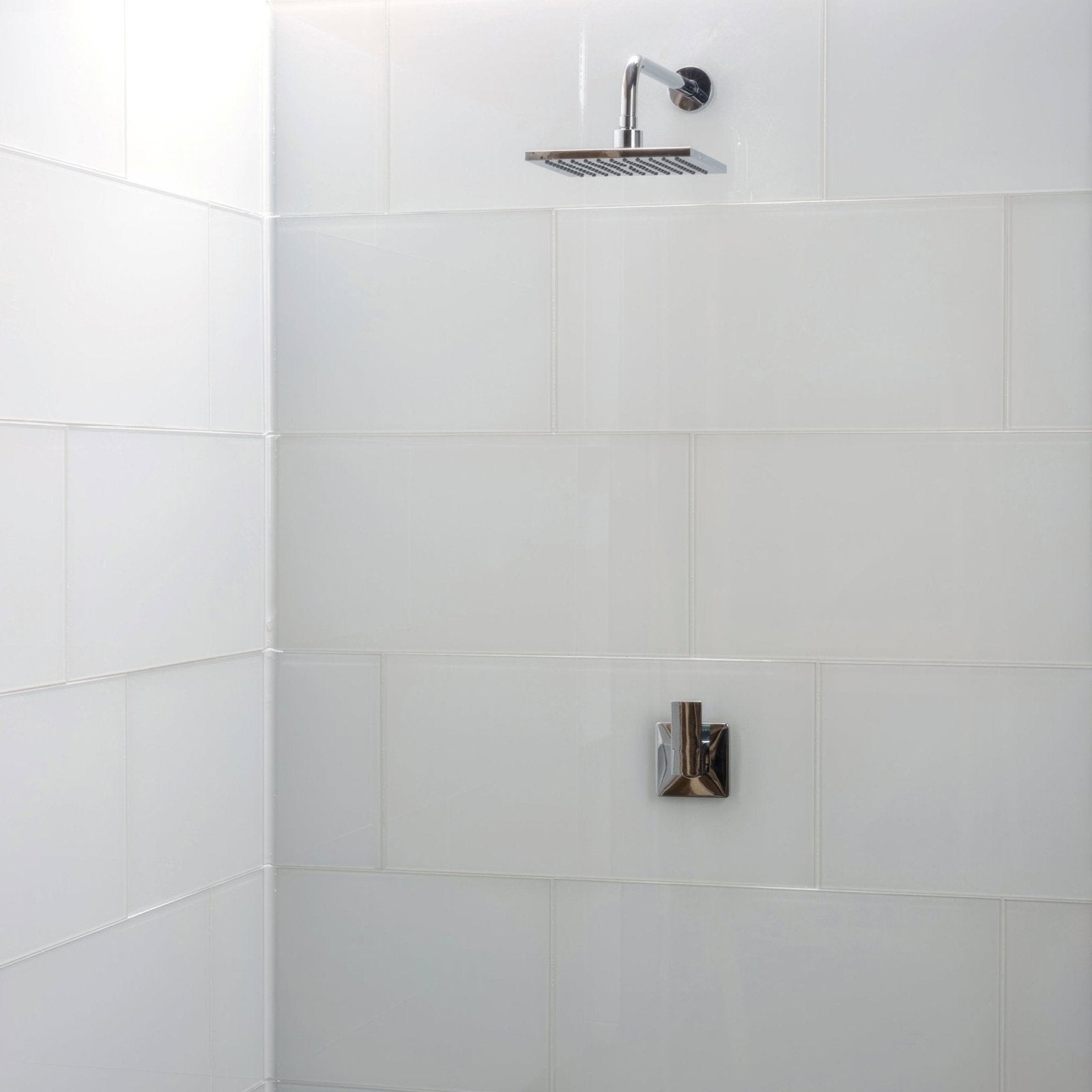 Arctic Clear Glass 600 x 300mm clear glass tiles with a chrome square showerhead