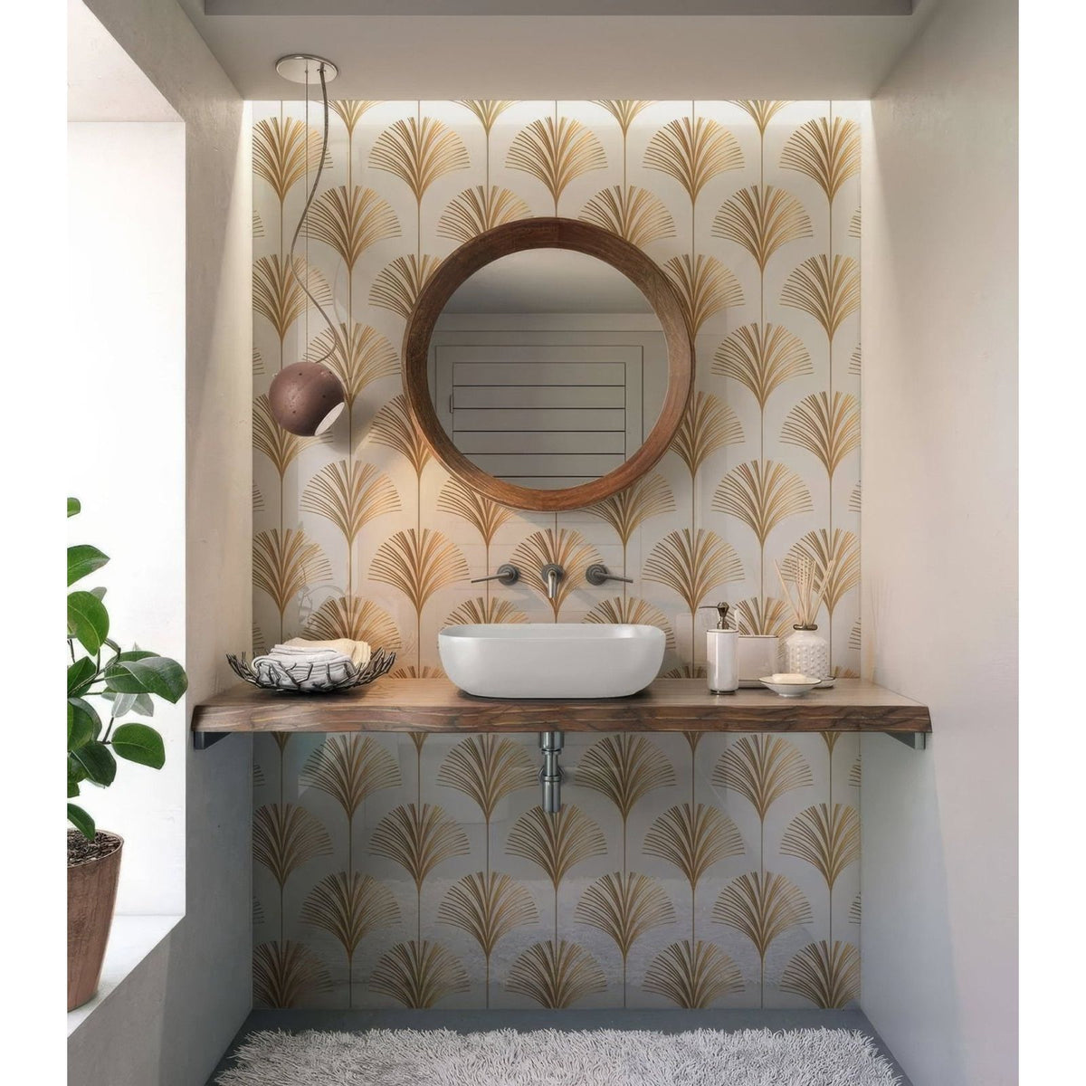Round wooden-framed mirror with natural finish against gold leaf patterned wallpaper in art deco palm martini shower panel setting