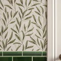 The arts & crafts willow 60x30cm wallpaper features olive green leafy branches on off-white with a green tile border