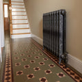 Antique-style black cast iron radiator with ornate scrollwork detailing in arundel brown buff and green finish
