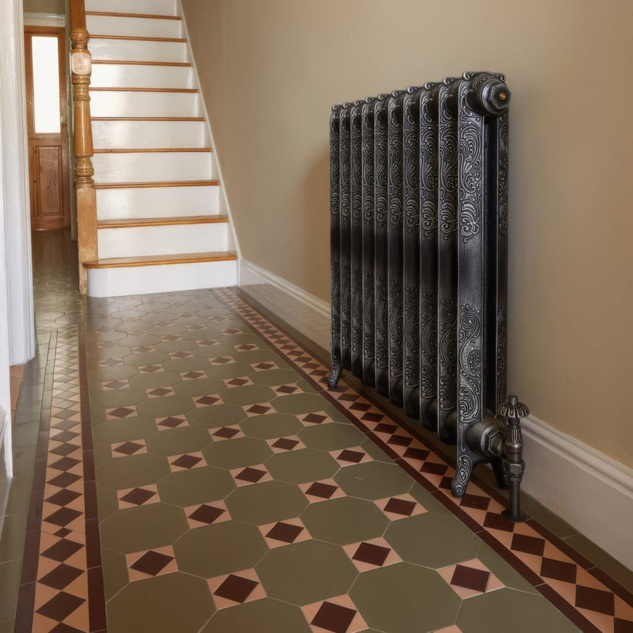 Antique-style black cast iron radiator with ornate scrollwork detailing in arundel brown buff and green finish