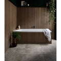 White rectangular bathtub with sleek modern design set against vertical wood paneling in ascoli porcelain grigio 40 x 60cm