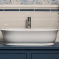 White oval ceramic sink with sleek chrome faucet in the Ascot Blue Omega Dado bathroom fixture collection