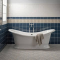 White freestanding Ascot Blue Victoria Moulding bathtub with chrome faucet and beige towel draped over the side