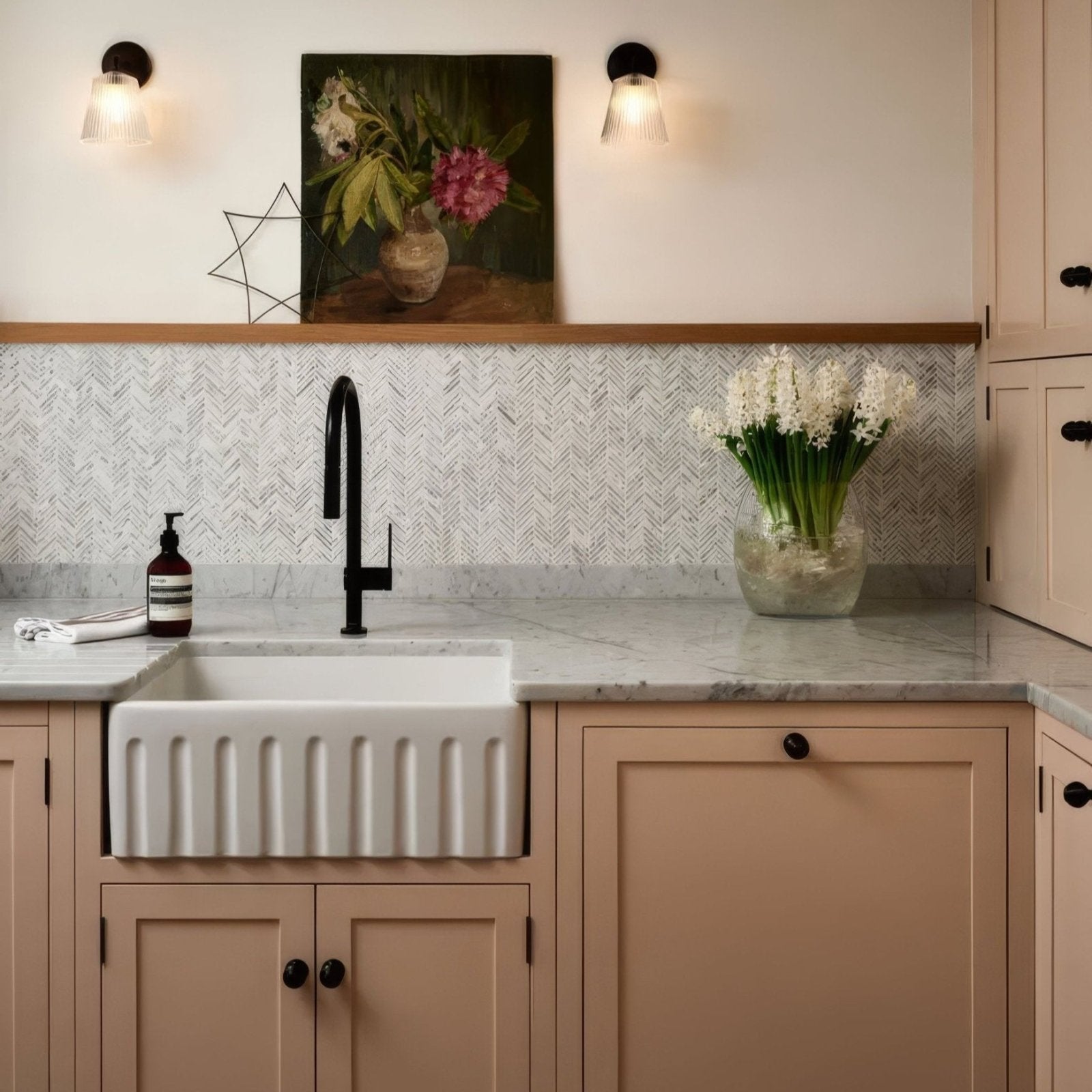 White ceramic farmhouse sink with vertical ridges paired with Athens Carrara marble mosaic backsplash panel
