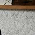 White marble mosaic tile in a herringbone pattern made from athens carrara marble for decorative wall use