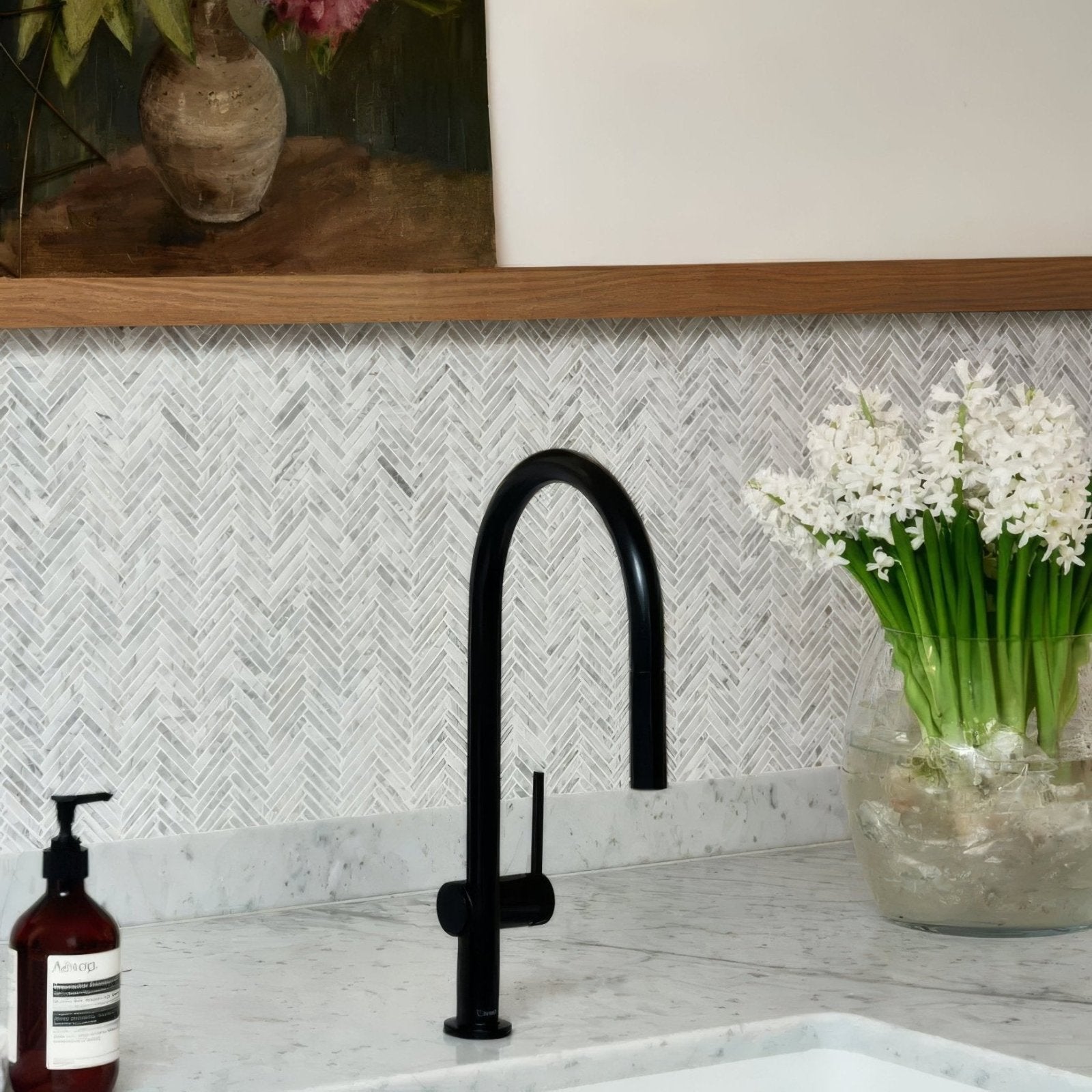 Black matte kitchen faucet with curved spout and single handle featured with athens carrara marble mosaic background