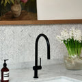 Athens Carrara Marble Mosaic white marble herringbone mosaic behind a black single-handle tap