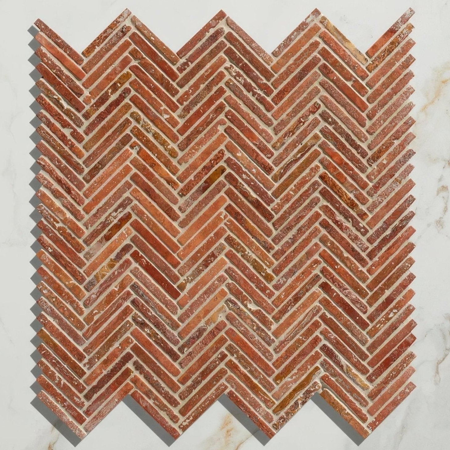 Reddish-brown reclaimed brick mosaic tile in a herringbone pattern from the athens rosso travertine mosaic collection