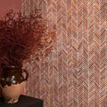 Athens Rosso Travertine Mosaic reddish-brown travertine herringbone mosaic styled with an earthenware vase