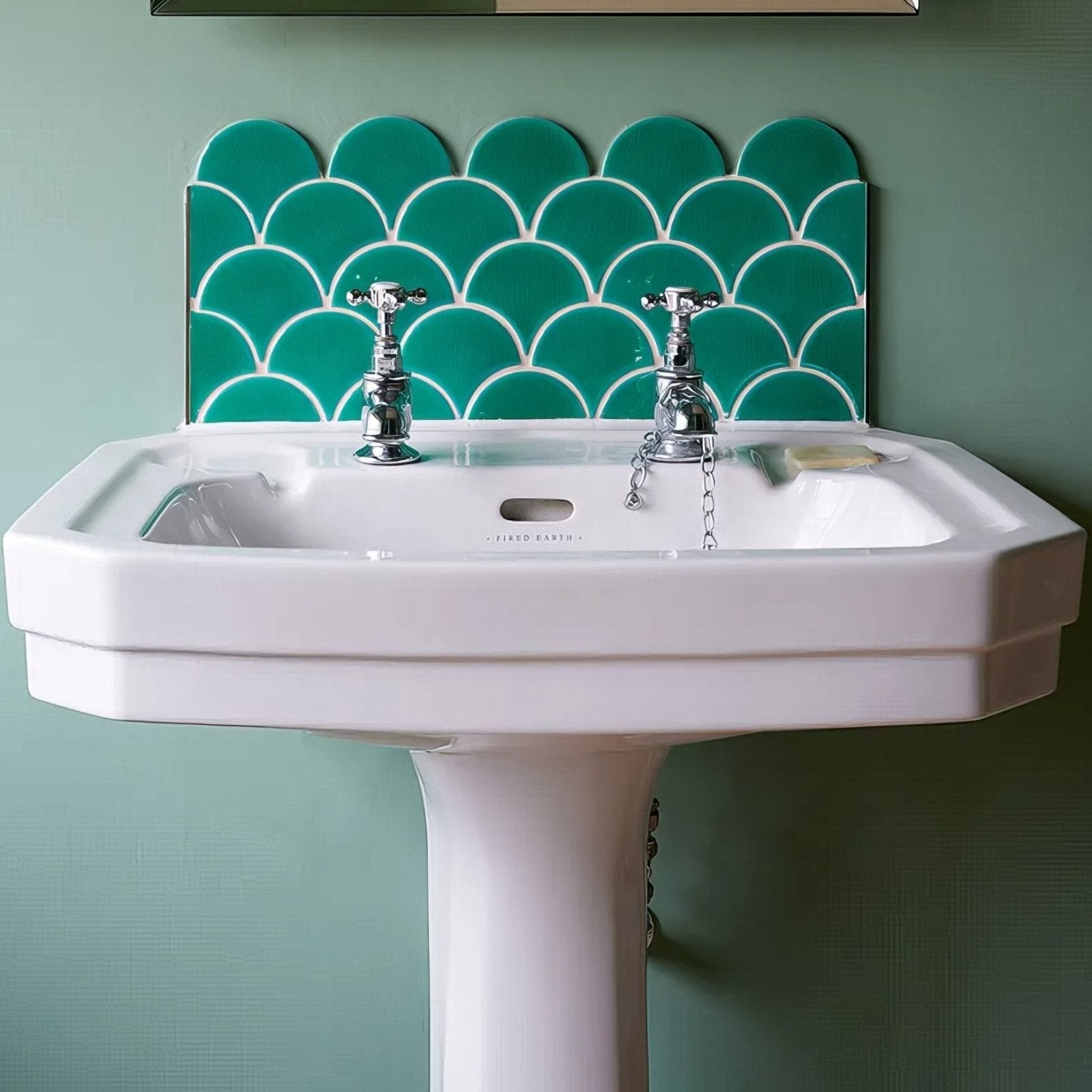 White ceramic pedestal sink with chrome faucets and teal scalloped atlantis porcelain mosaic emerald tile backsplash