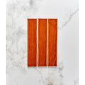 Three rectangular glossy burnt caramel ceramic tiles from avebury arranged vertically on a marble surface