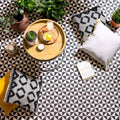 Avignon Black on Dover White black and white geometric pattern tiles styled with a wooden tray of potted plants and candles