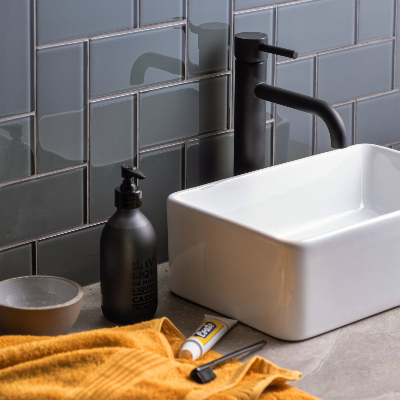 Black matte pump bottle with embossed text on the surface featured in Avon clear glass brick product design