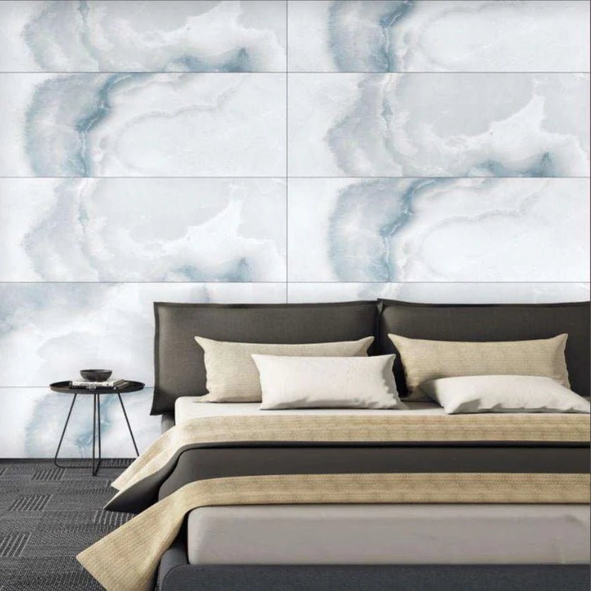 Azul Onyx 60 x 120cm white and grey marble-effect tiles with an upholstered bed and throw blanket