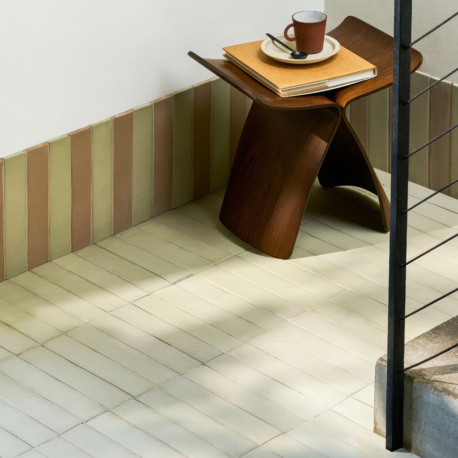 A sleek dark wood side table with a curved organic design and smooth finish named balance olive tile