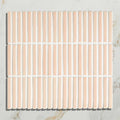A square bamboo porcelain mosaic blush tile with vertical peach ceramic strips and white grout lines