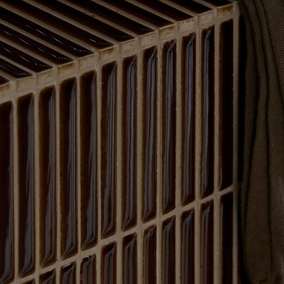 Dark brown glossy bamboo porcelain mosaic caramel tiles arranged in a grid with light beige grout lines