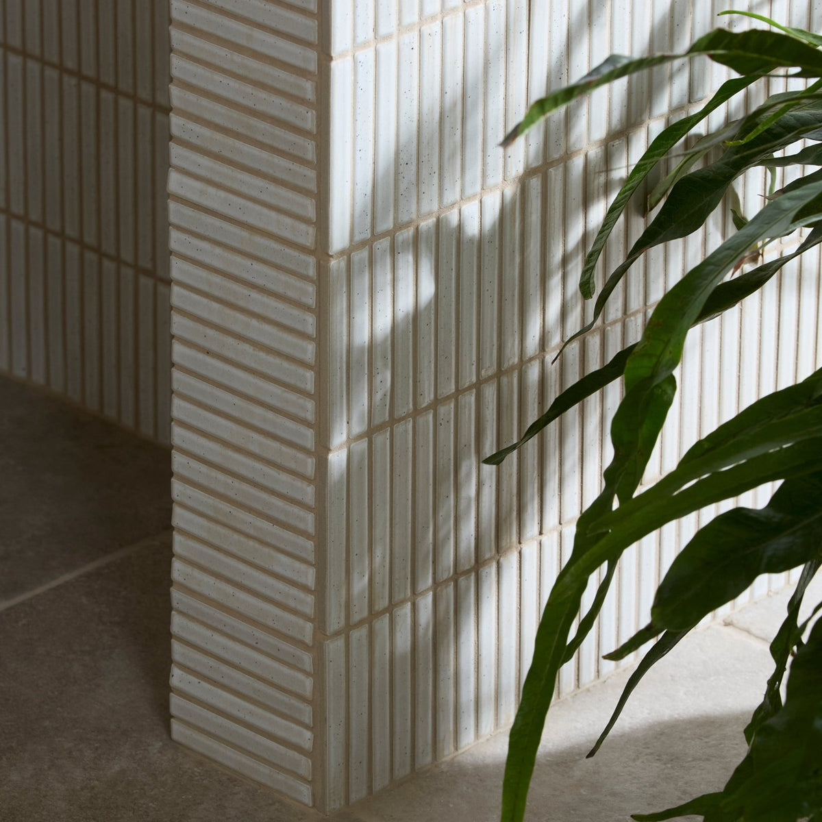 White ceramic bamboo porcelain mosaic vintage white tiles with vertical ridges lining the wall corner