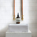 Bamboo Porcelain Mosaic White white ribbed porcelain mosaic styled with an amber glass pump bottle